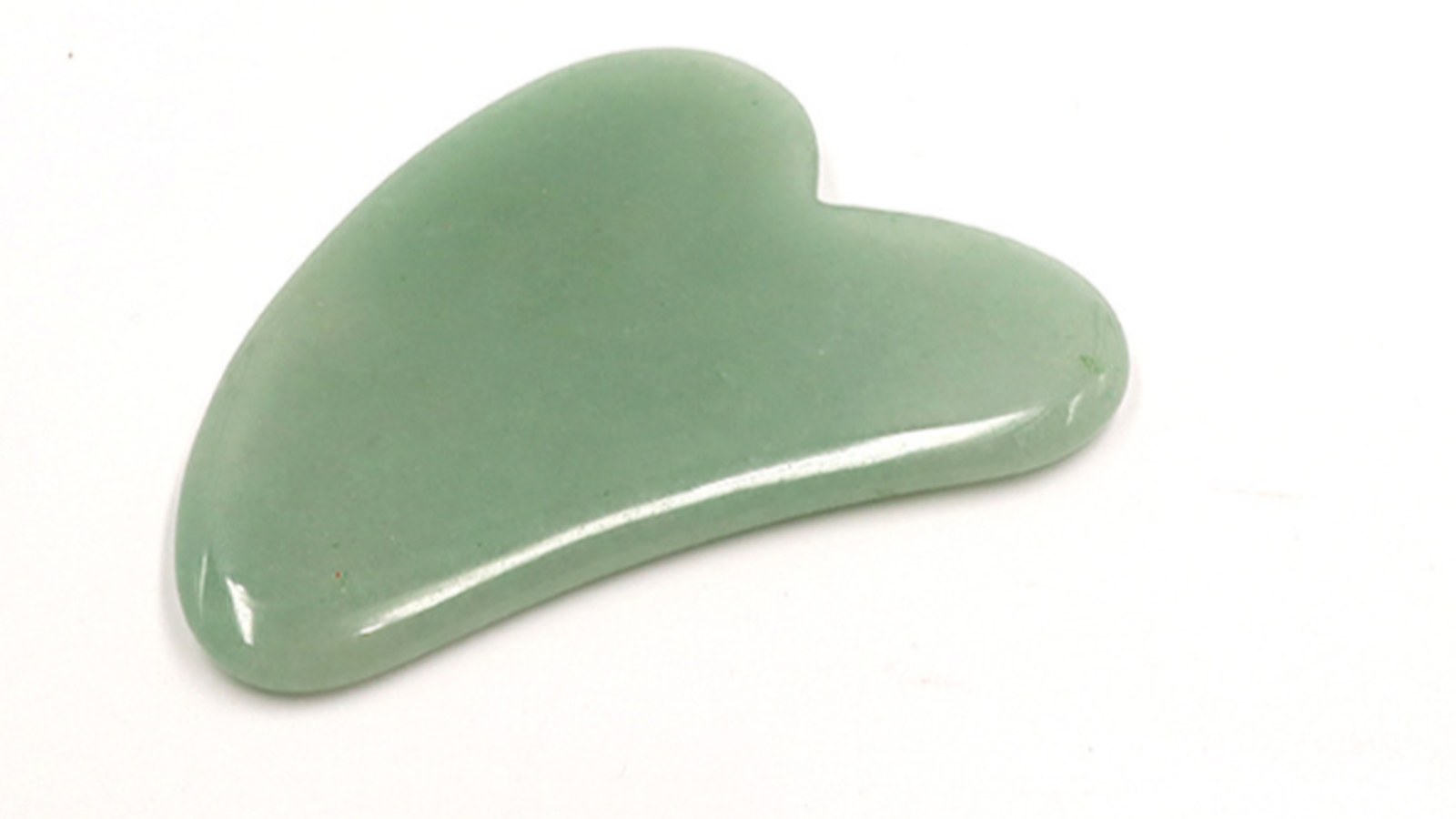 Green jade style gua sha tool on a clean white background