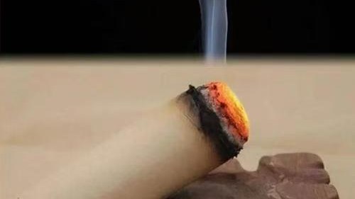 Burning moxa stick with gentle smoke for room ventilation awareness