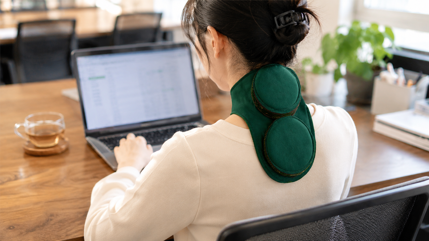 Portable smokeless moxa warmer placed on the upper back while working at a desk