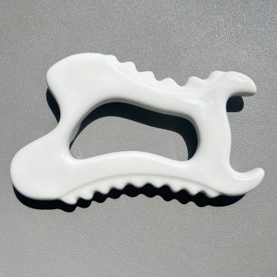 White ceramic Gua Sha massage tool close up