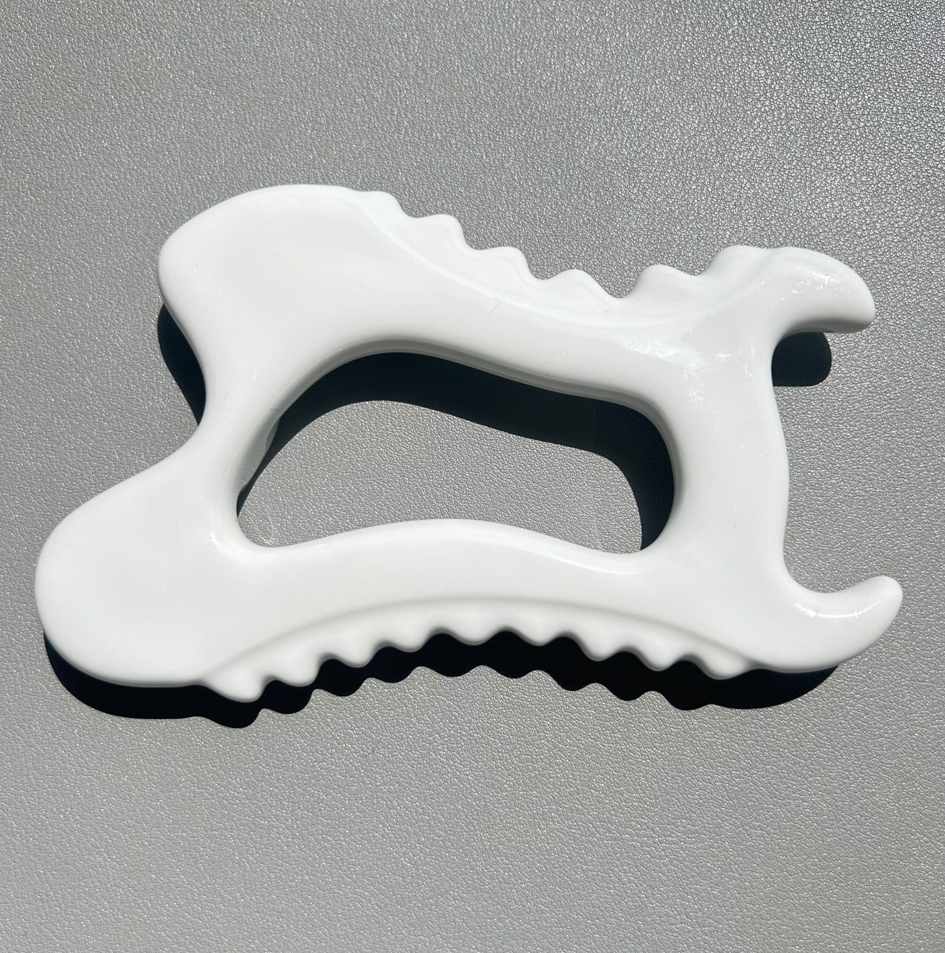 White ceramic Gua Sha massage tool close up